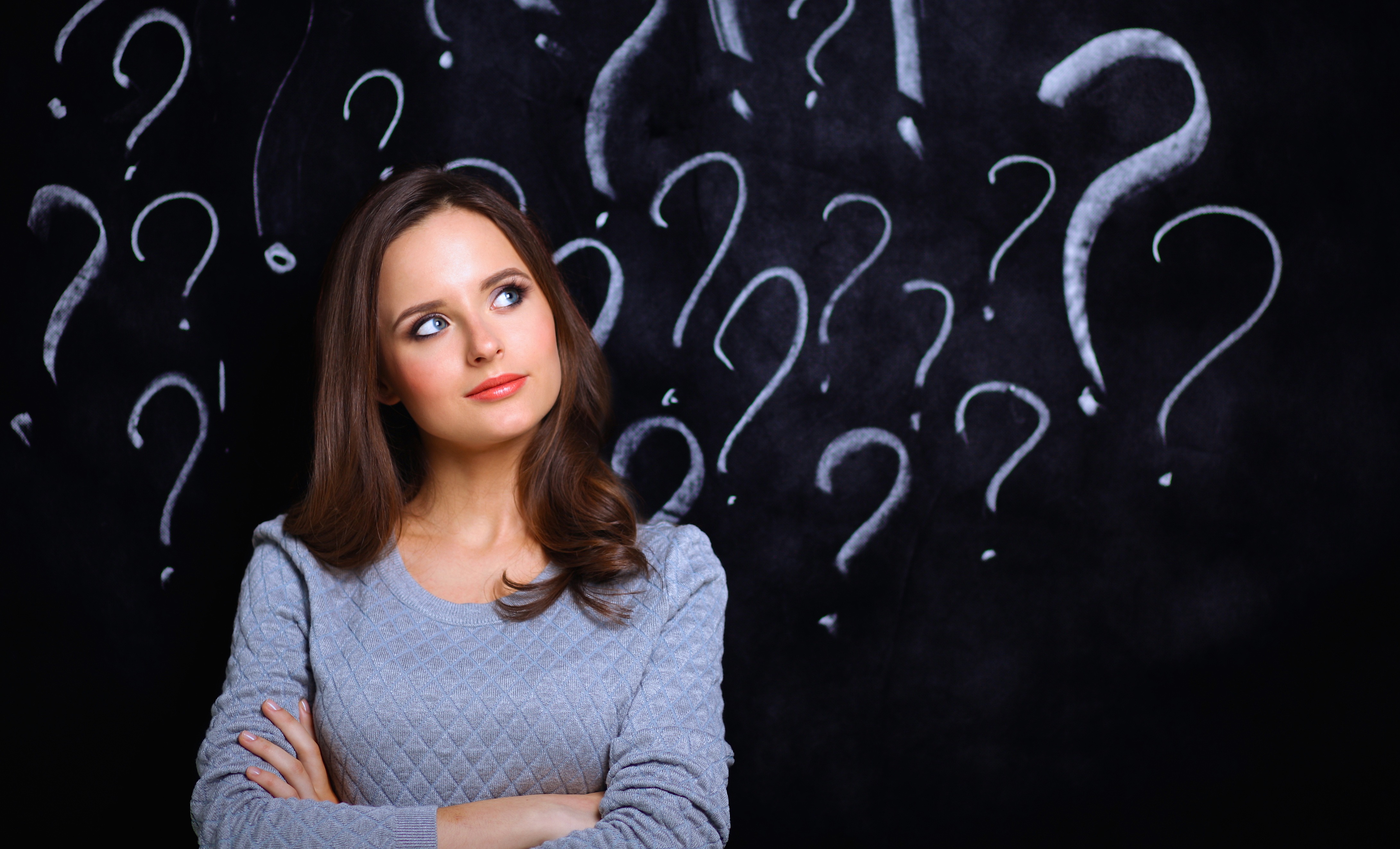 Young girl with question mark on a gray background
